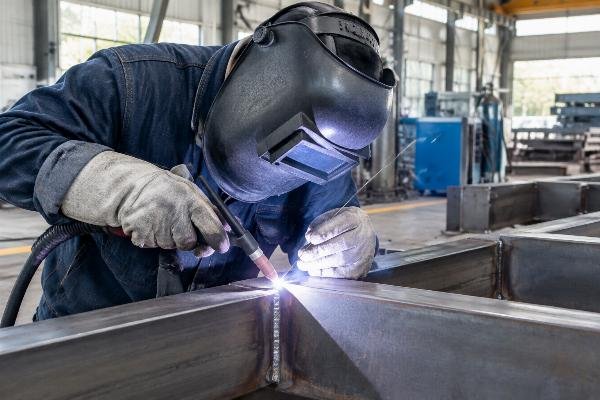 Close-up view of certified welder performing TIG welding on steel structure